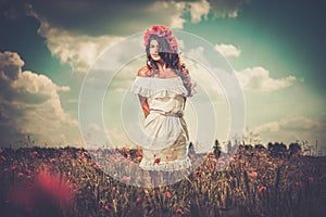 Girl wearing white summer dress in poppy filed