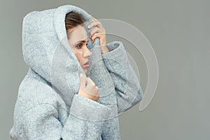 Girl wears large deep coat hood.