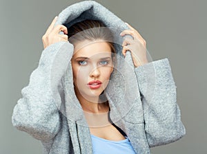Girl wears large deep coat hood.