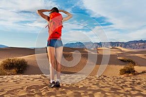 Girl wears rucksack, stands with Death valley view