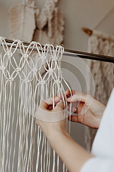 The process of weaving macrame. Hands weave macrame decor photo