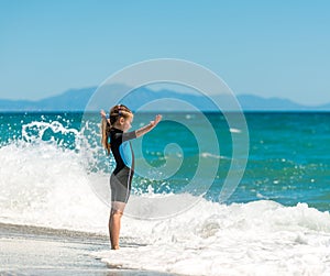 Girl in a wetsuit on the beach