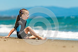 Girl in a wetsuit on the beach