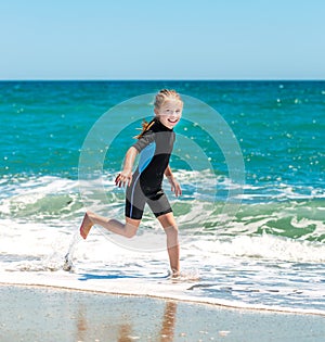 Girl in a wetsuit on the beach