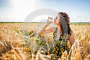 Girl in wheat field. Girl pours milk into a glass