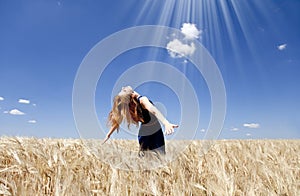 Girl at wheat field in summer day.