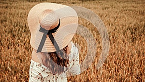 Girl wheat field summer. Happy young woman in sun hat in summer wheat field at sunset. Nature, summer holidays, vacation