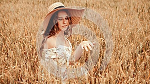 Girl wheat field summer. Happy young woman in sun hat in summer wheat field at sunset. Nature, summer holidays, vacation