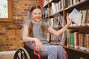 Girl in wheelchair selecting book in library