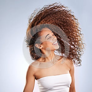 Girl, whip and hair in studio happy for healthy, volume and natural cosmetic care with treatment for curls. Woman, calm