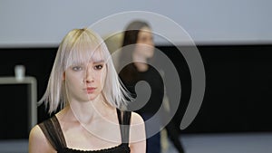 Girl with white albino hair moving on runway catwalk podium. Female model defile