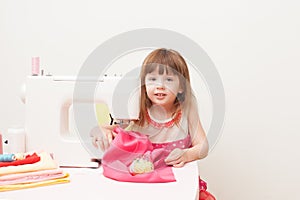 The girl is engaged in needlework using sewing machine