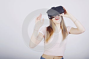 Girl on a white background plays virtual reality. Games and films vr. Emotions