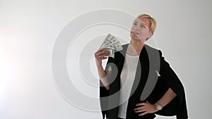Girl on a white background waving a fan out of dollars.