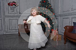 A girl in a white dress and a fur coat is spinning in a white dress in the hall