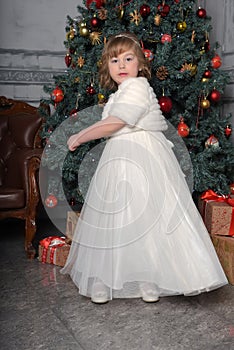 A girl in a white dress and a fur coat is spinning in a white dress in the hall