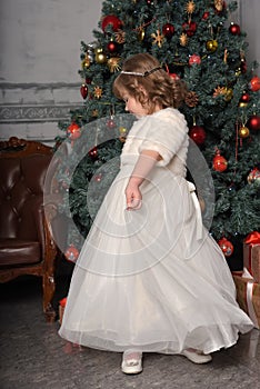 A girl in a white dress and a fur coat is spinning in a white dress in the hall