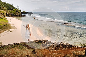 A girl in a white dress on the Gris-Gris beach on the island of Mauritius photo
