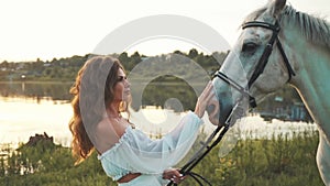 Girl in a white dress on a horse. Bride riding a horse in the field.