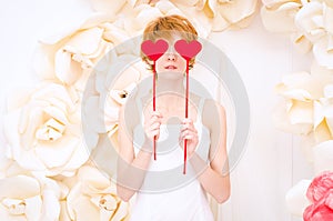 Girl in white dress with red heart in hands