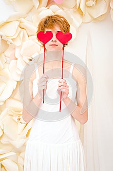 Girl in white dress with red heart in hands