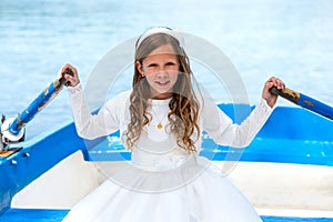 Girl in white dress rowing on lake.