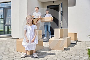 Girl in a white dress sits on box in yard