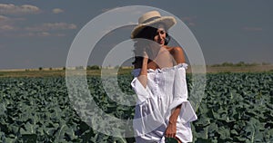 A girl in a white dress stands on the field