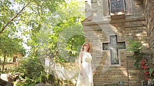 Girl in a white dress walks in gothic church. tourist attractions looks