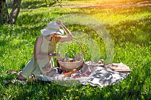 Girl in a white hat and a small dog on picnic