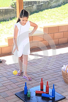 Girl in white playing skittles