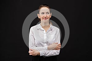 Girl in a white shirt grins and clasped hands on a black background