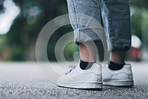 A girl with white shoes walking on the street