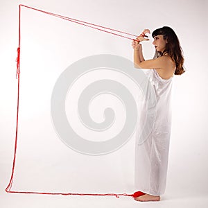 Girl white silk nightie making frame with red thread on white background