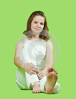 Girl in white sitting on green