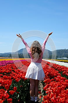 collection of videos and photos where a girl in a white skirt walks through field with tulips blue background sky