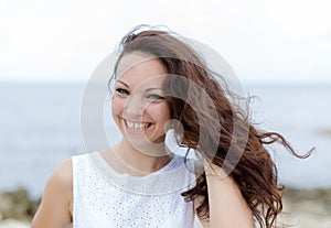 Girl in white sleeveless dress looking at camera laughing