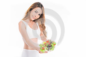 Girl in a white sport bra holds a salad bowl