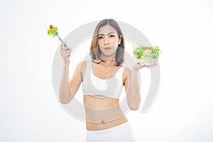 Girl in a white sport bra holds a salad bowl