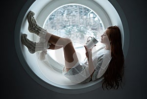 Girl in white sport wear lies on window