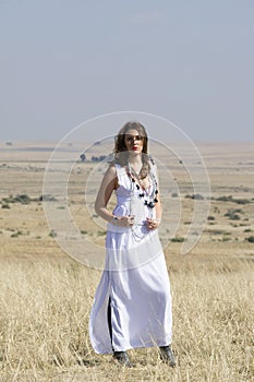 Girl in white standing outside in field