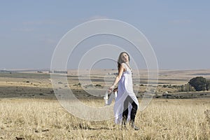 Girl in white standing outside in field
