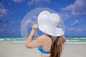 Girl with white sun hat sky and carribean sea