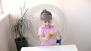 A girl in a white T-shirt holds a cup of tea and a liver in the form of a red heart.