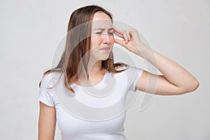 A girl in a white T-shirt is tormented by dizziness and disorientation photo