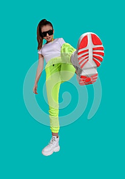 Girl in a white T-shirt and yellow sweatpants on a colored background