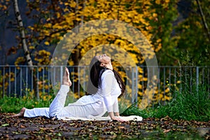 Girl in white in yoga position in the park photo