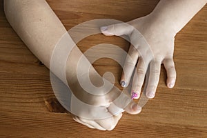 girl who paints her nails with nail polish behind a wooden stall