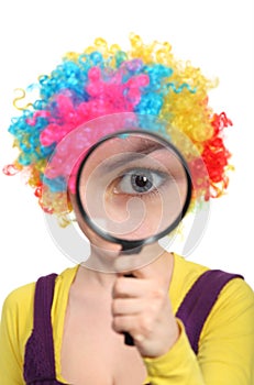 Girl in wig looking through magnifying glass