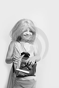 Girl with wig in pink dress with backpack. Back to school and learning concept. Pupil with happy face